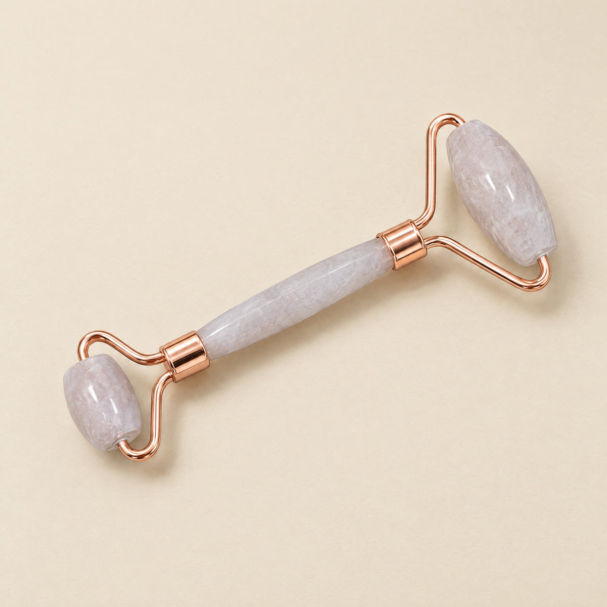 Rose quartz crystal face roller with rose-gold-tone frame