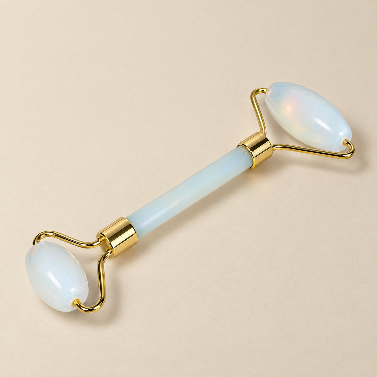 Opal face roller with a gold-tone frame, milky white opalite stones
