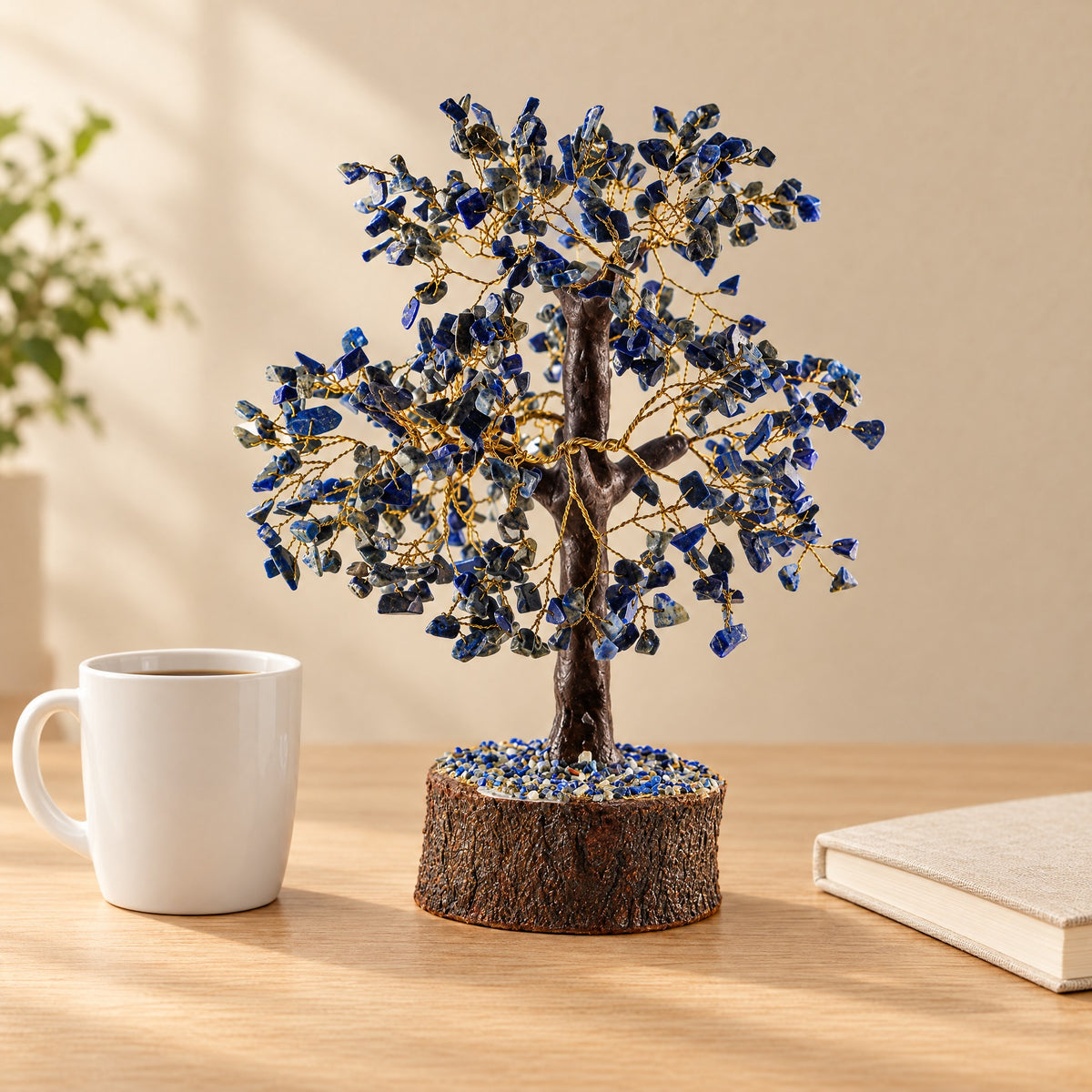 Lapis lazuli crystal tree on a desk beside a coffee mug for size