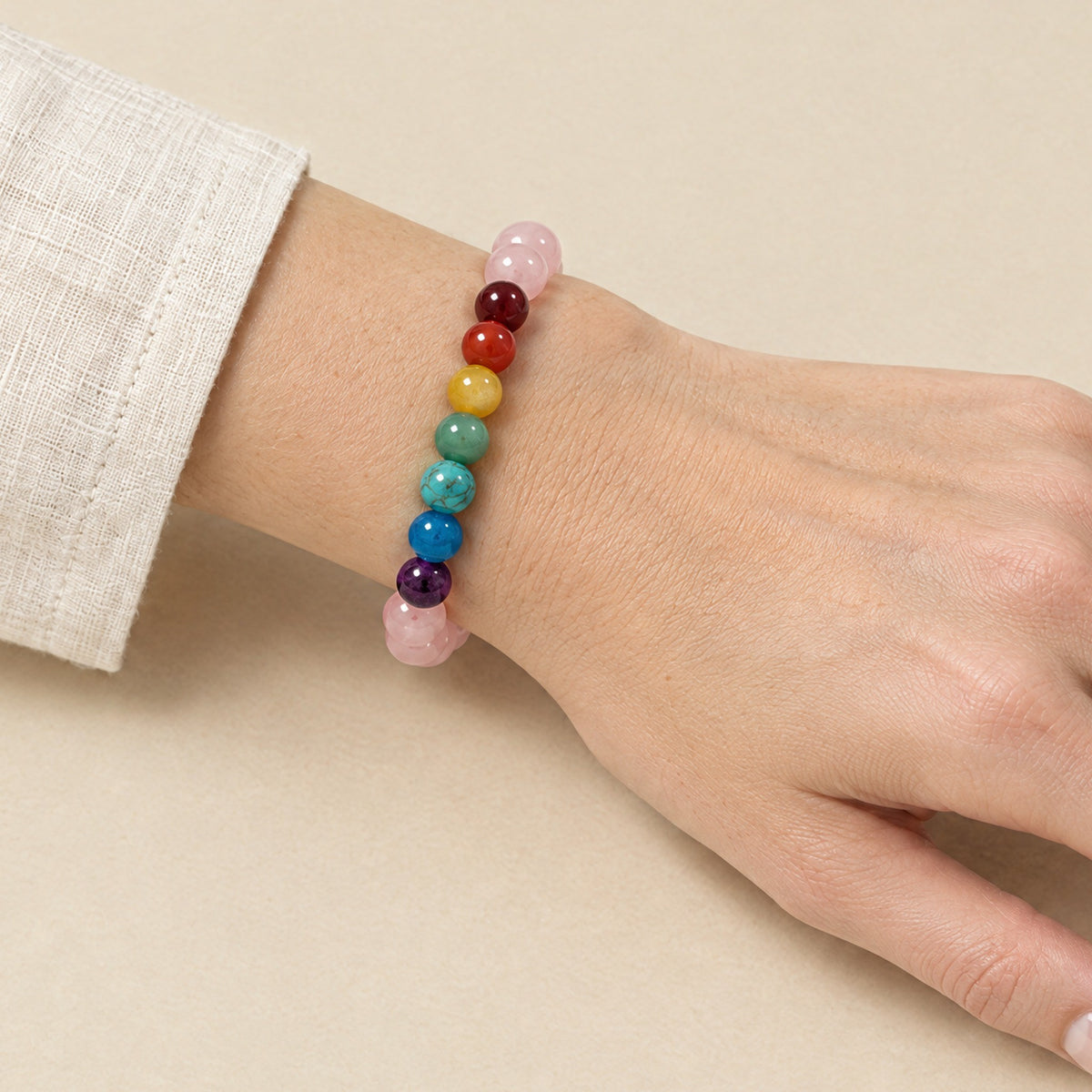 7 Chakra and rose quartz bracelet worn on a woman's wrist