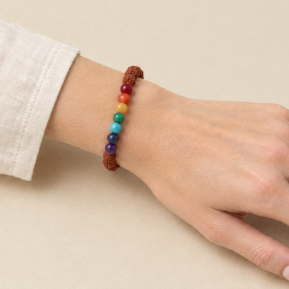 Seven chakra and rudraksha bracelet worn on a woman's wrist