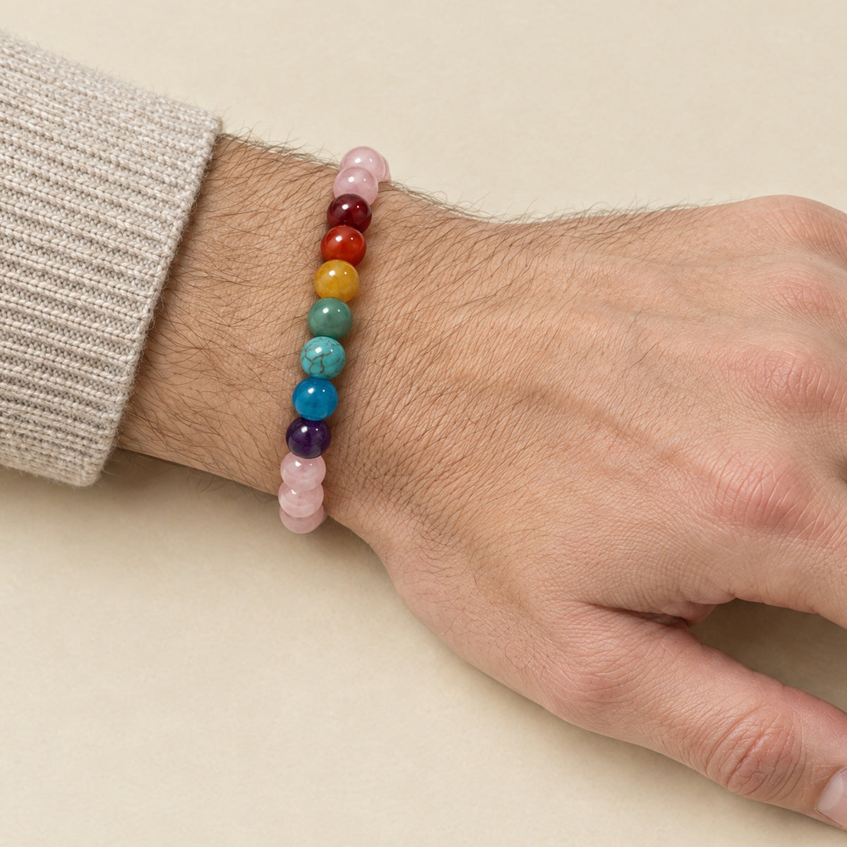 7 Chakra and rose quartz bracelet worn on a man's wrist