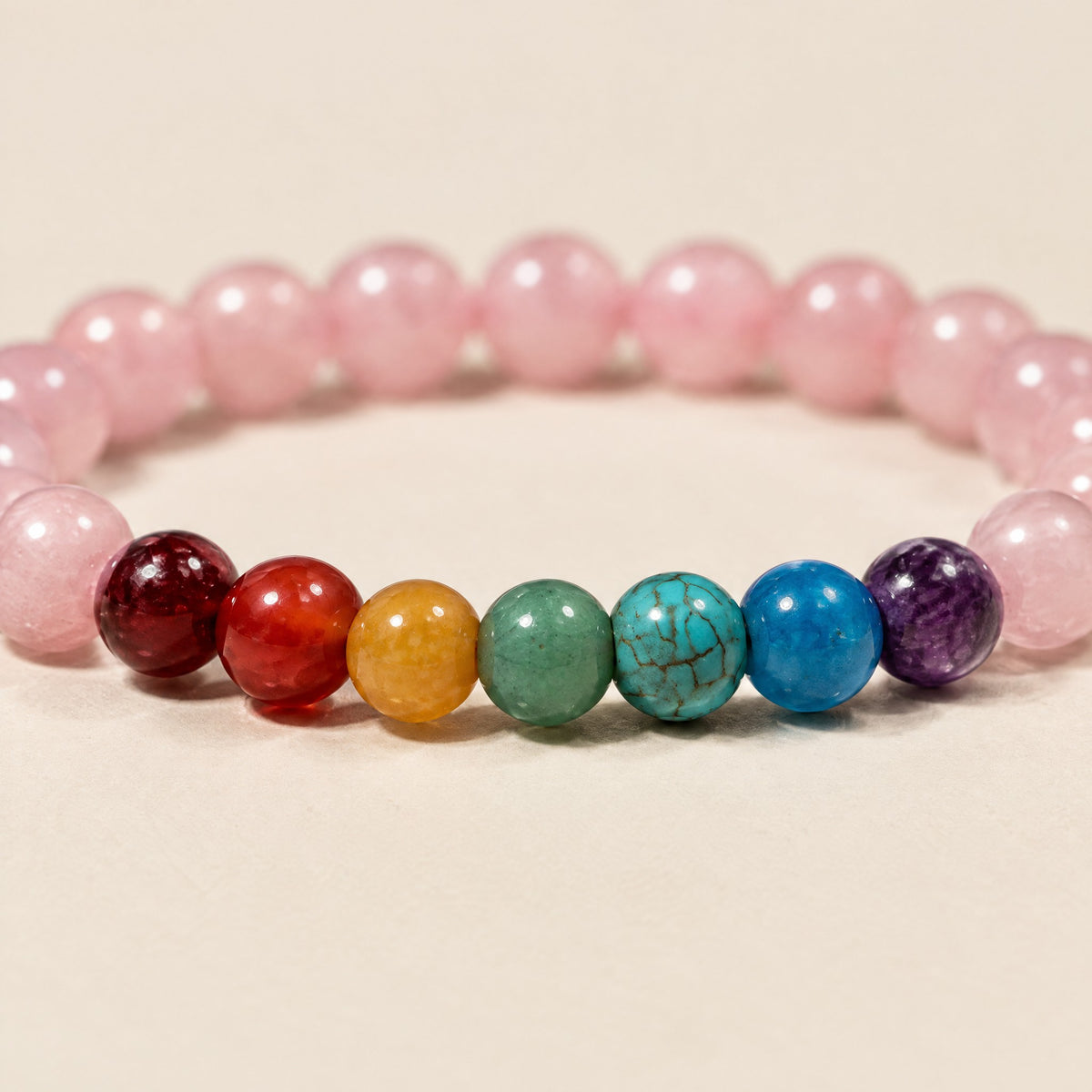 Close-up of the 7 Chakra beads beside rose quartz