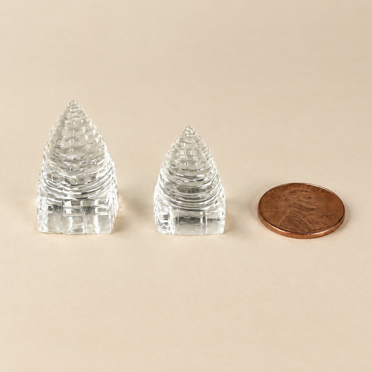 1.5 inch and 1 inch crystal quartz Sri Yantras next to a US penny for size