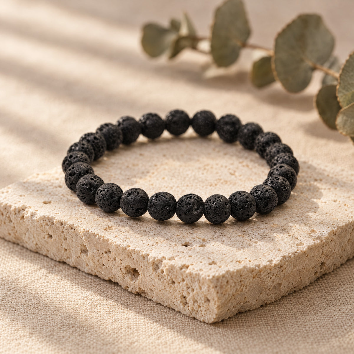 Black lava stone bracelet on a travertine stone