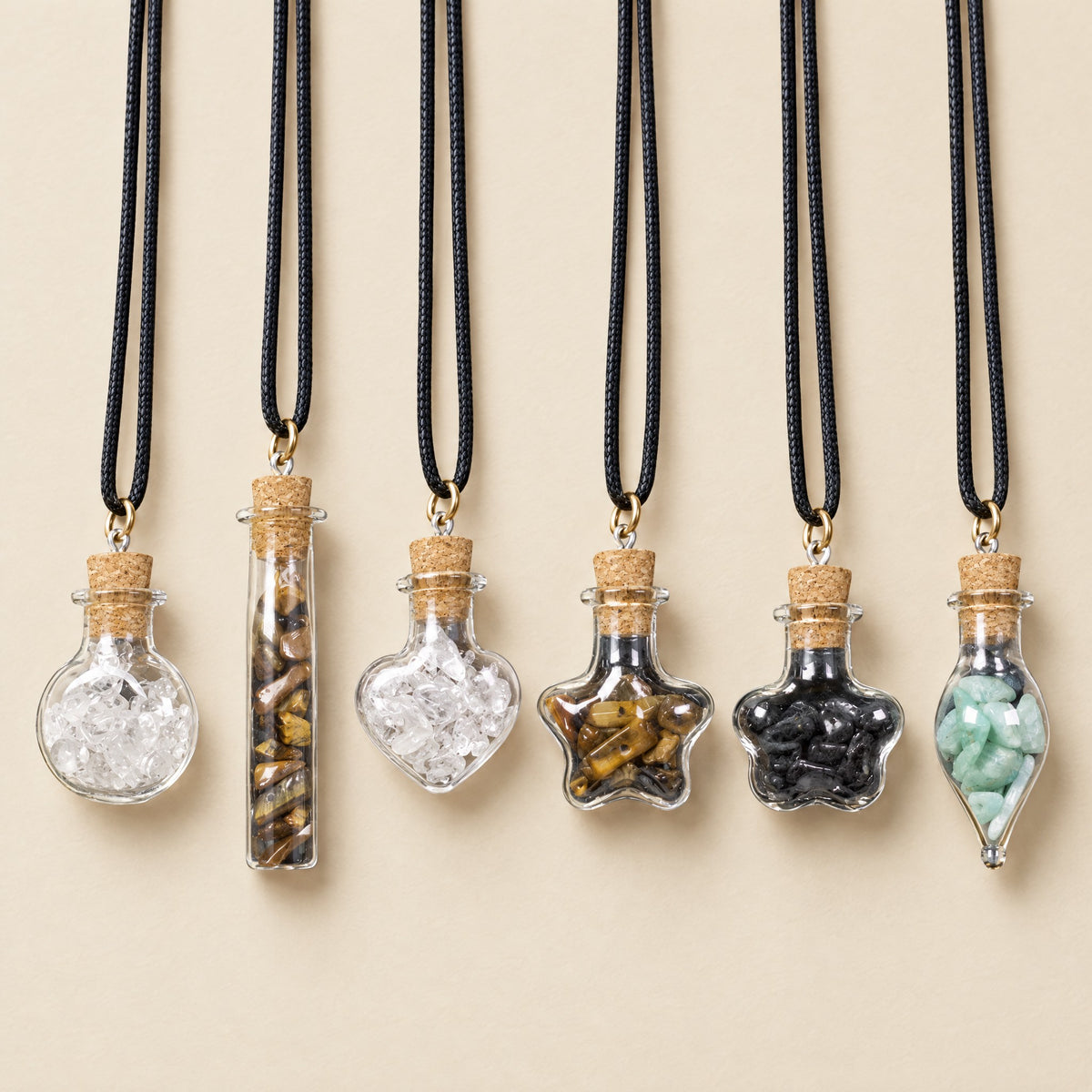 Six crystal wish bottle necklaces on black cords: clear quartz, tiger eye, black tourmaline and amazonite bottles