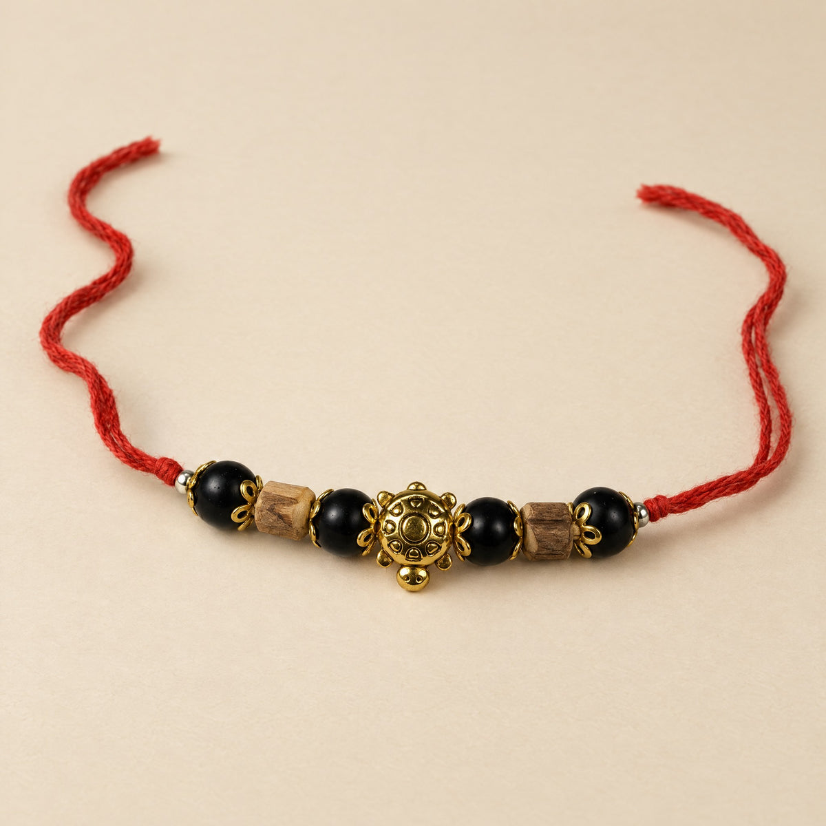 Red string bracelet with Shaligram stone beads, Tulsi wood beads and a gold-tone charm
