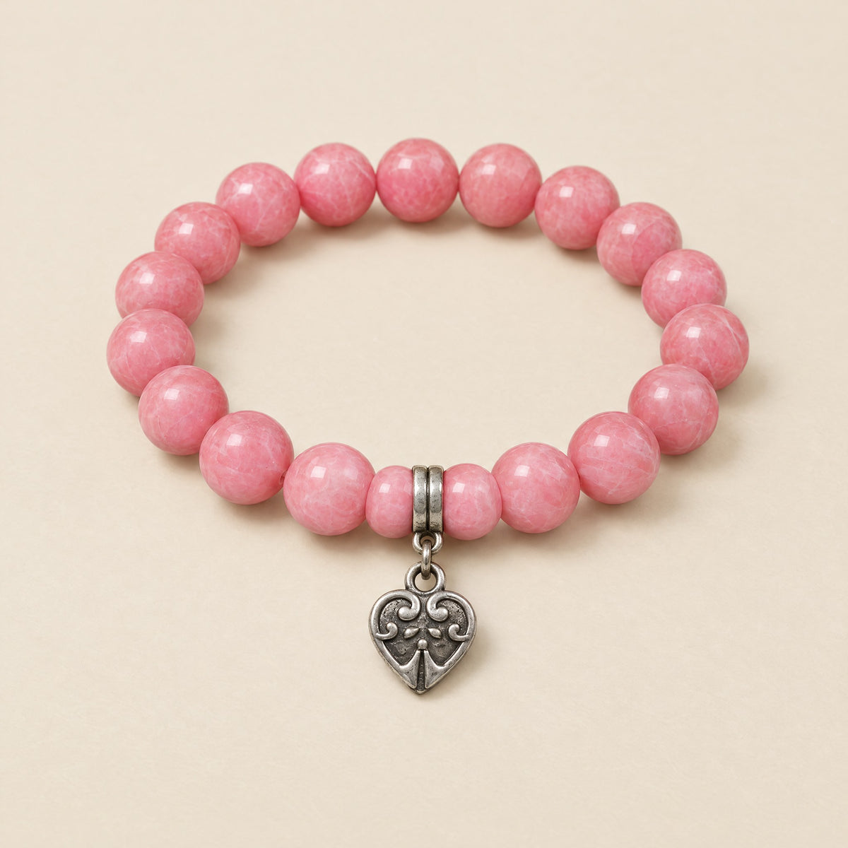 Heart Charm Bracelet: 8 mm pink onyx beads with a silver-tone heart charm