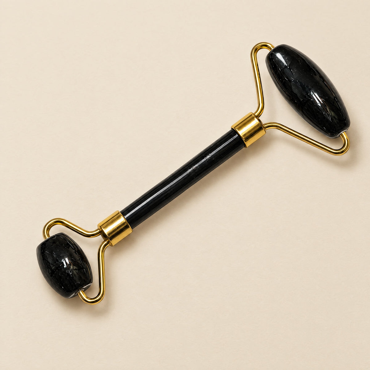 Black tourmaline face roller with gold-tone frame
