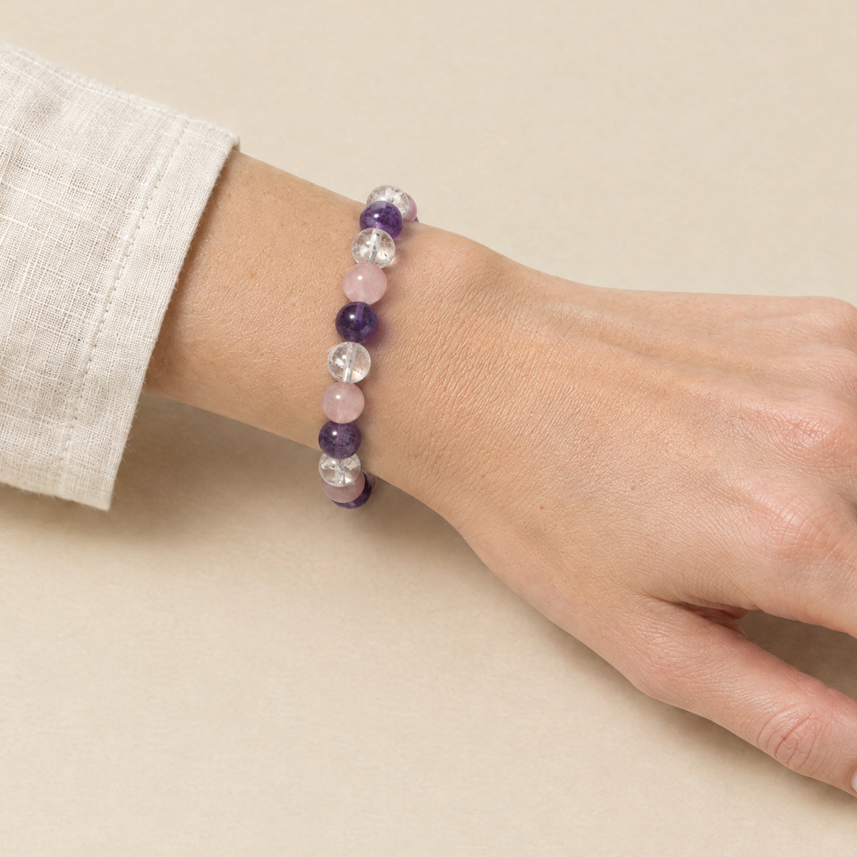 Amethyst, crystal and rose quartz bracelet worn on a woman's wrist