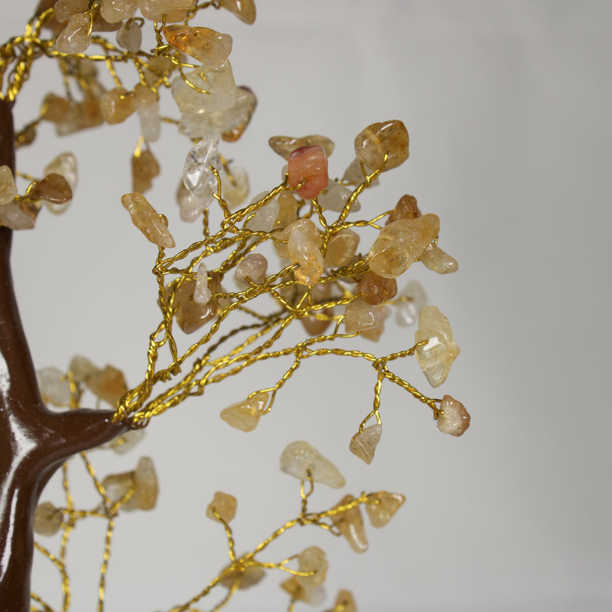 Close-up of honey-yellow citrine chips on gold-tone wire branches