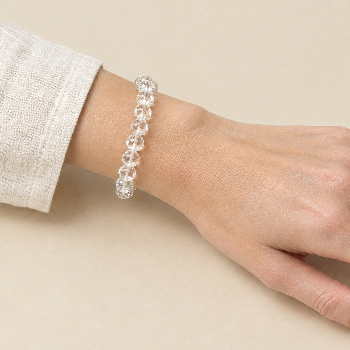 Faceted clear quartz crystal bracelet worn on a woman's wrist