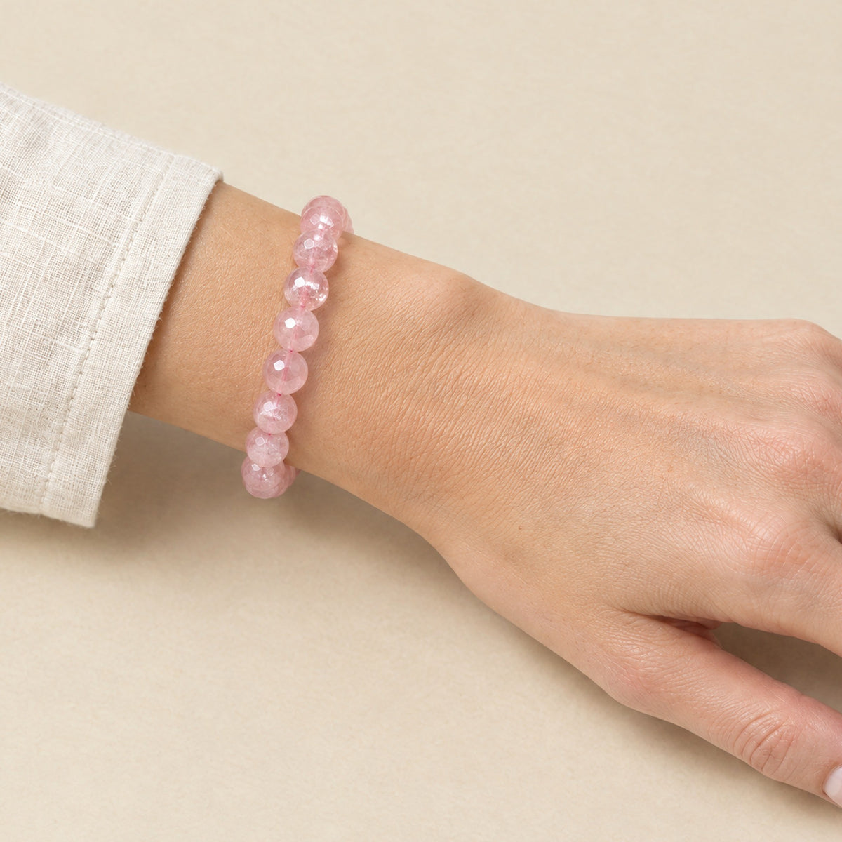 Faceted rose quartz bracelet worn on a woman's wrist
