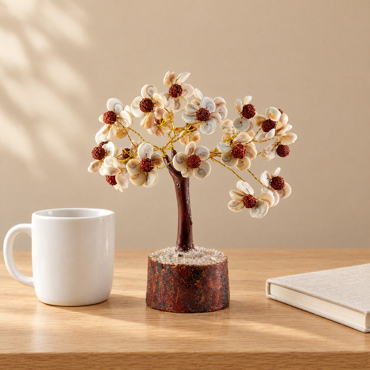 Gomti chakra and rudraksha gemstone tree on a desk beside a coffee mug for size