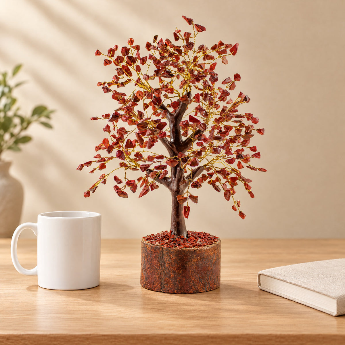 Red jasper gemstone tree on a desk beside a coffee mug for size