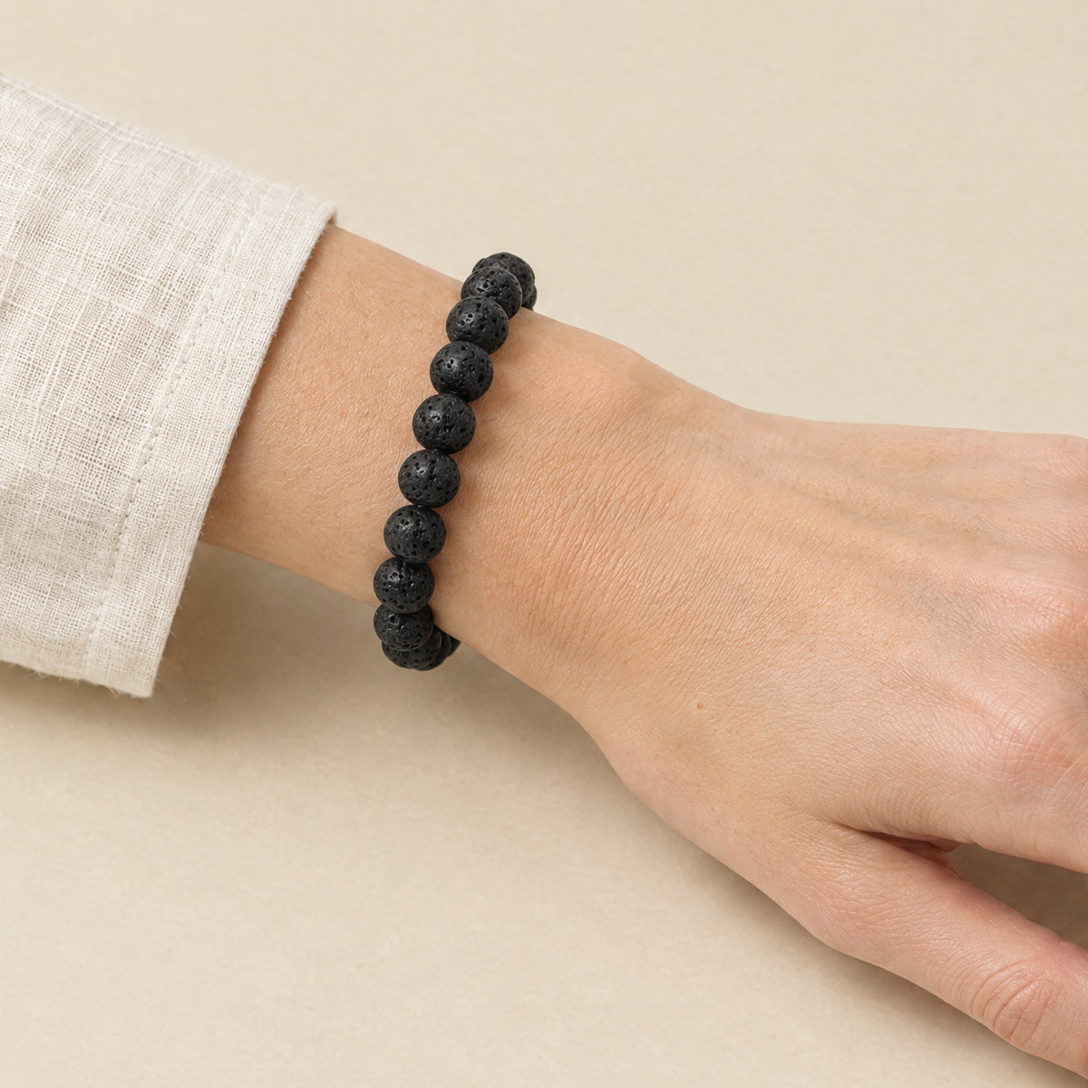 Black lava stone bracelet worn on a woman's wrist