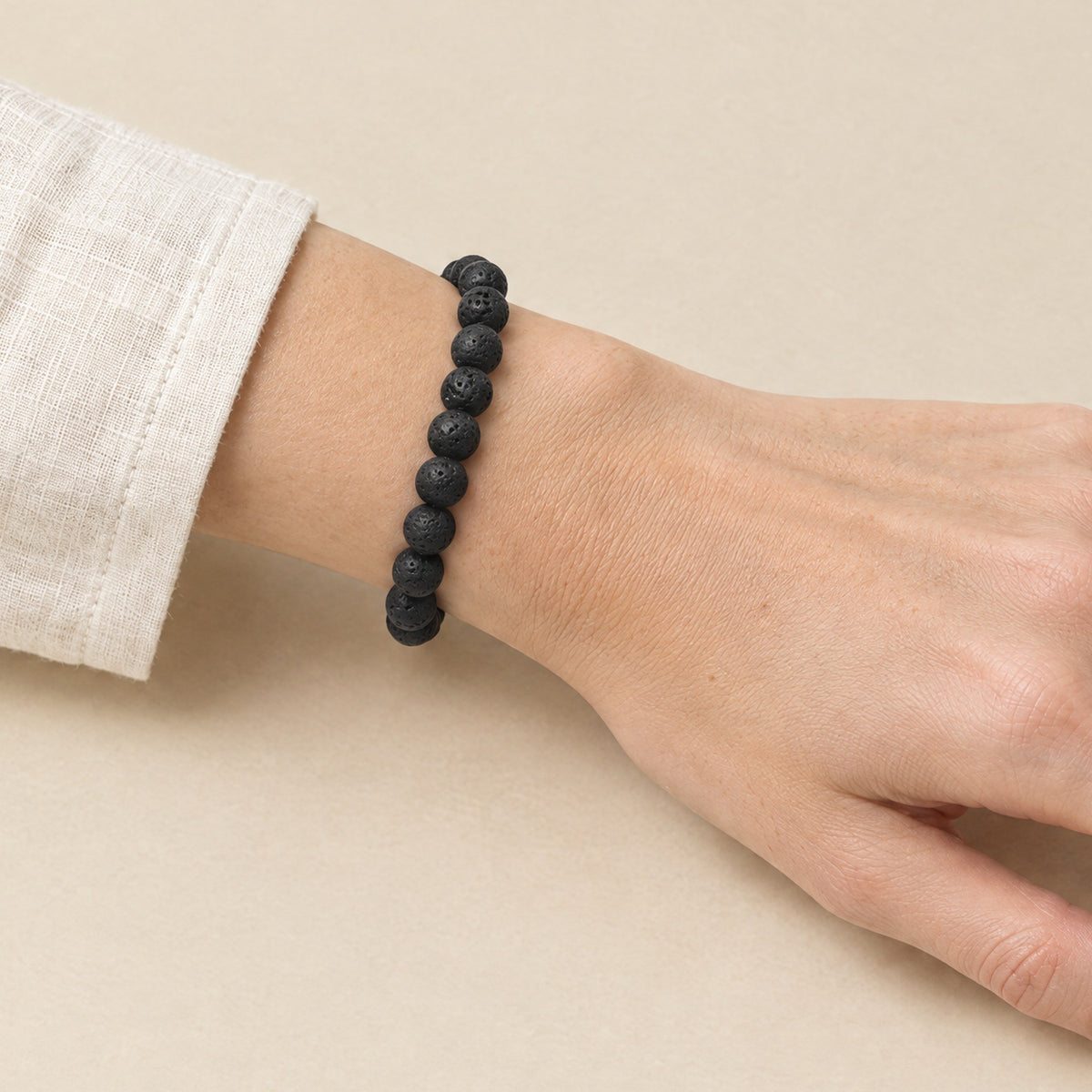 Lava stone Buddha bracelet worn on a woman's wrist