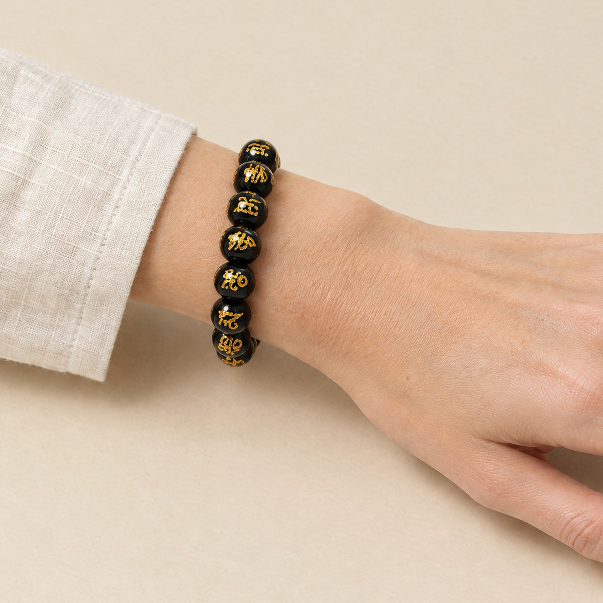 Om Mani Padme Hum bracelet worn on a woman's wrist