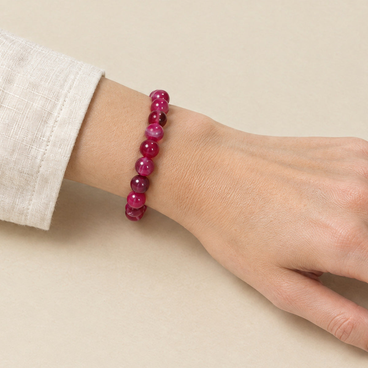 Pink onyx bracelet worn on a woman's wrist