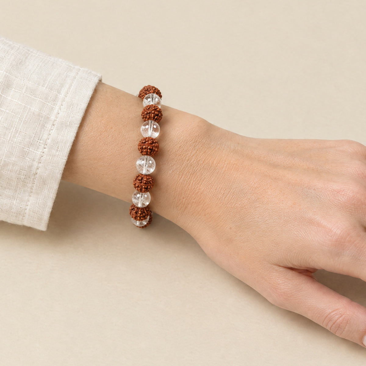 Rudraksha and clear quartz bracelet worn on a woman's wrist