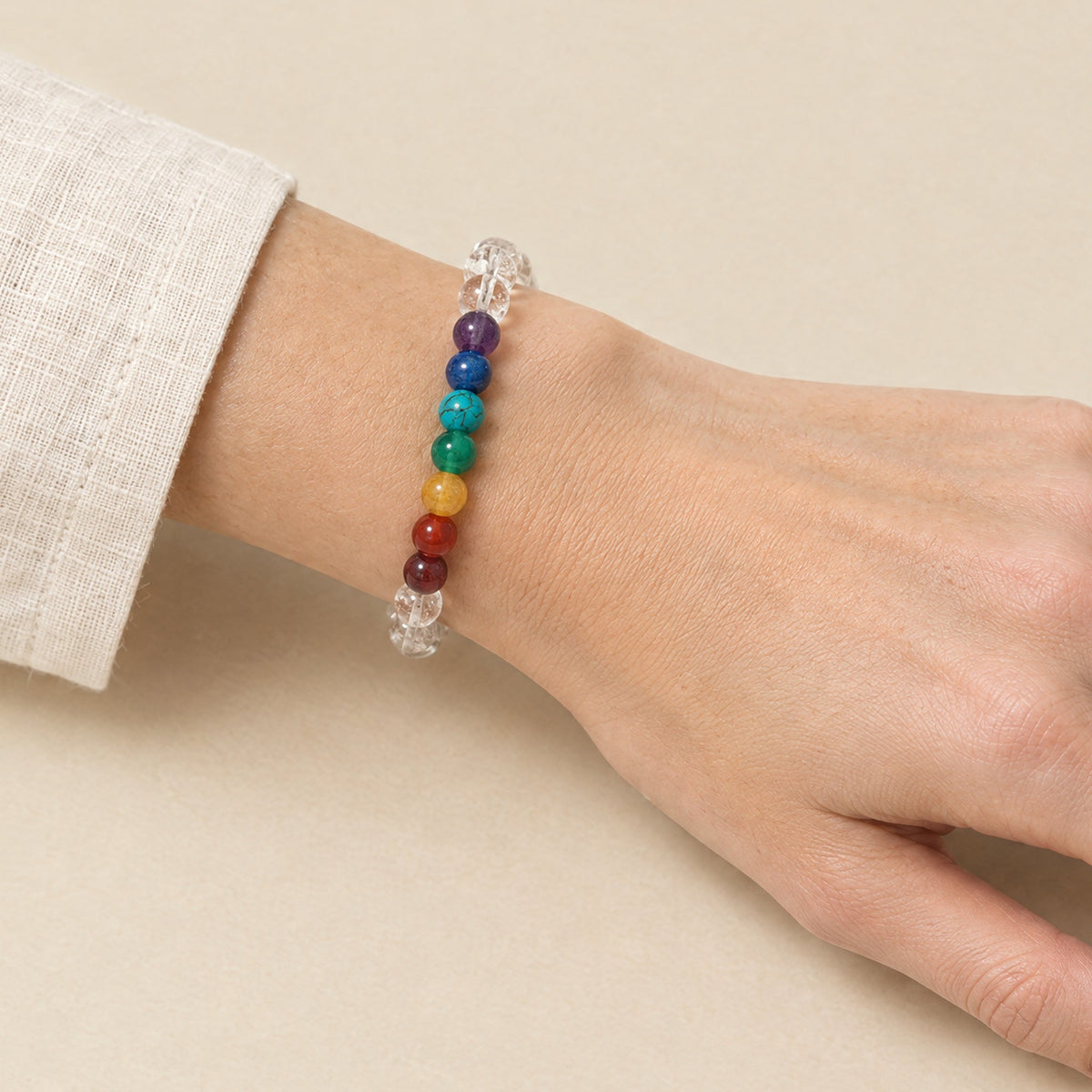 Seven chakra and crystal bracelet worn on a woman's wrist