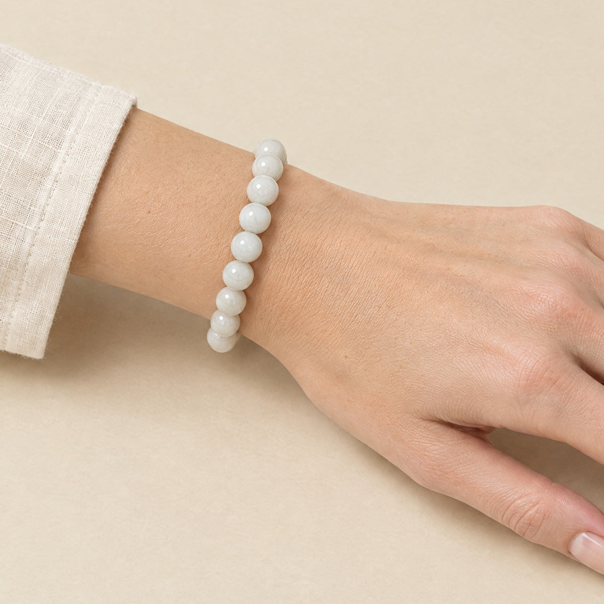White agate Buddha bracelet worn on a woman's wrist