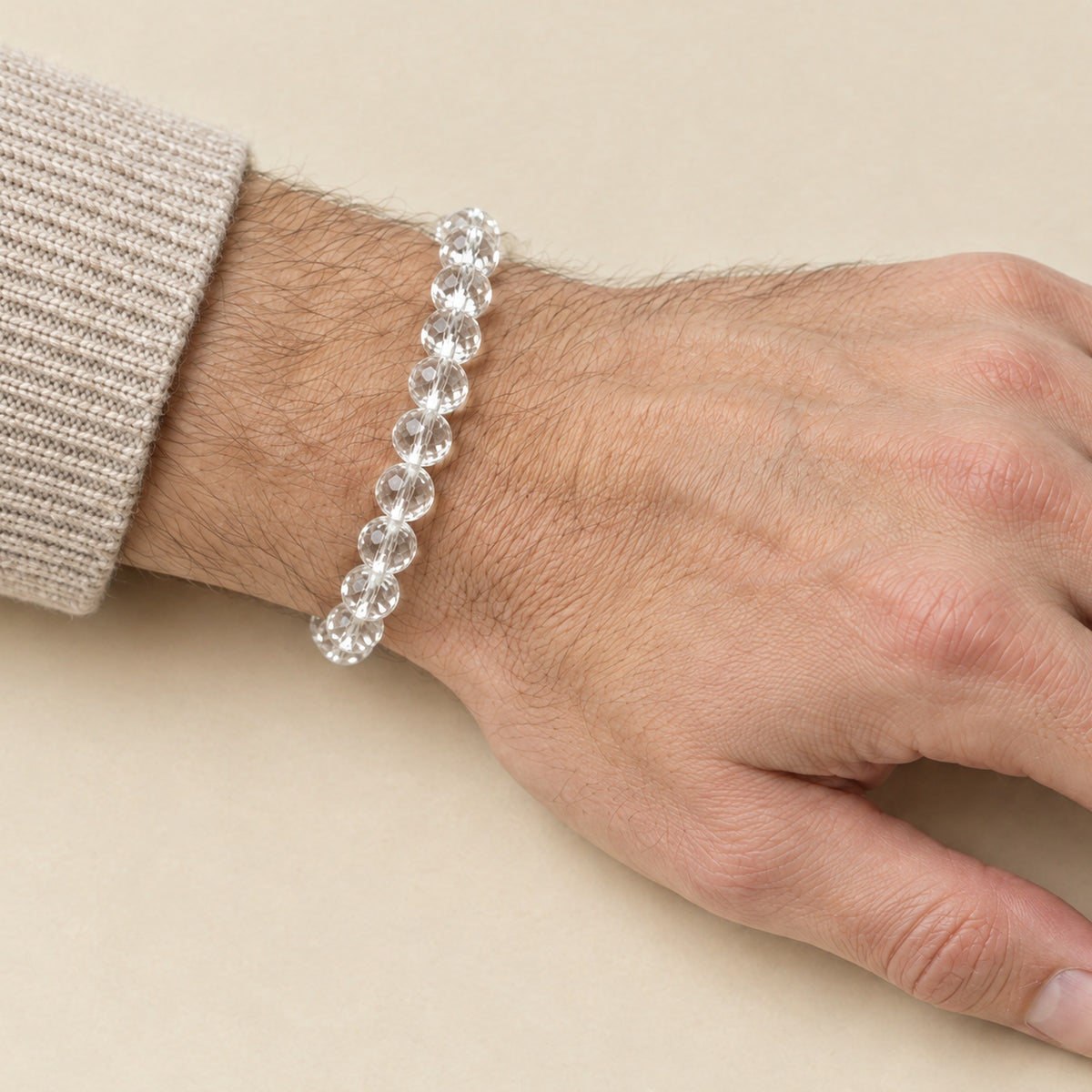 Faceted clear quartz crystal bracelet worn on a man's wrist