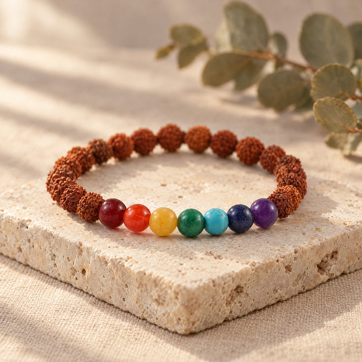 7 chakra and rudraksha bracelet on a travertine stone