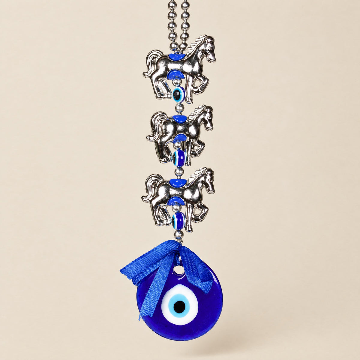 Blue glass evil eye wall hanging with three silver-tone lucky horse charms