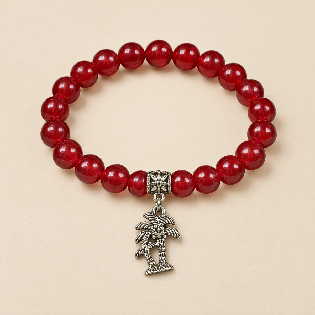 Palm Tree Charm Bracelet: 8 mm cherry onyx beads with a silver-tone palm tree charm
