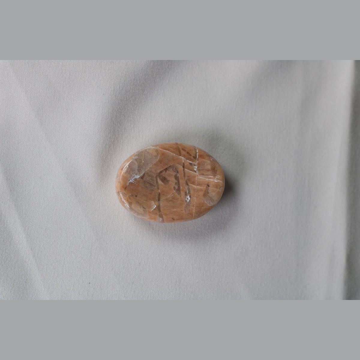 Unedited photo of the peach moonstone worry stone