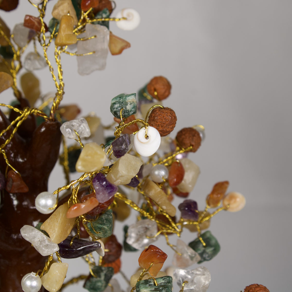 Close-up of rudraksha beads, pearls and Gomti Chakra shells on gold-tone wire
