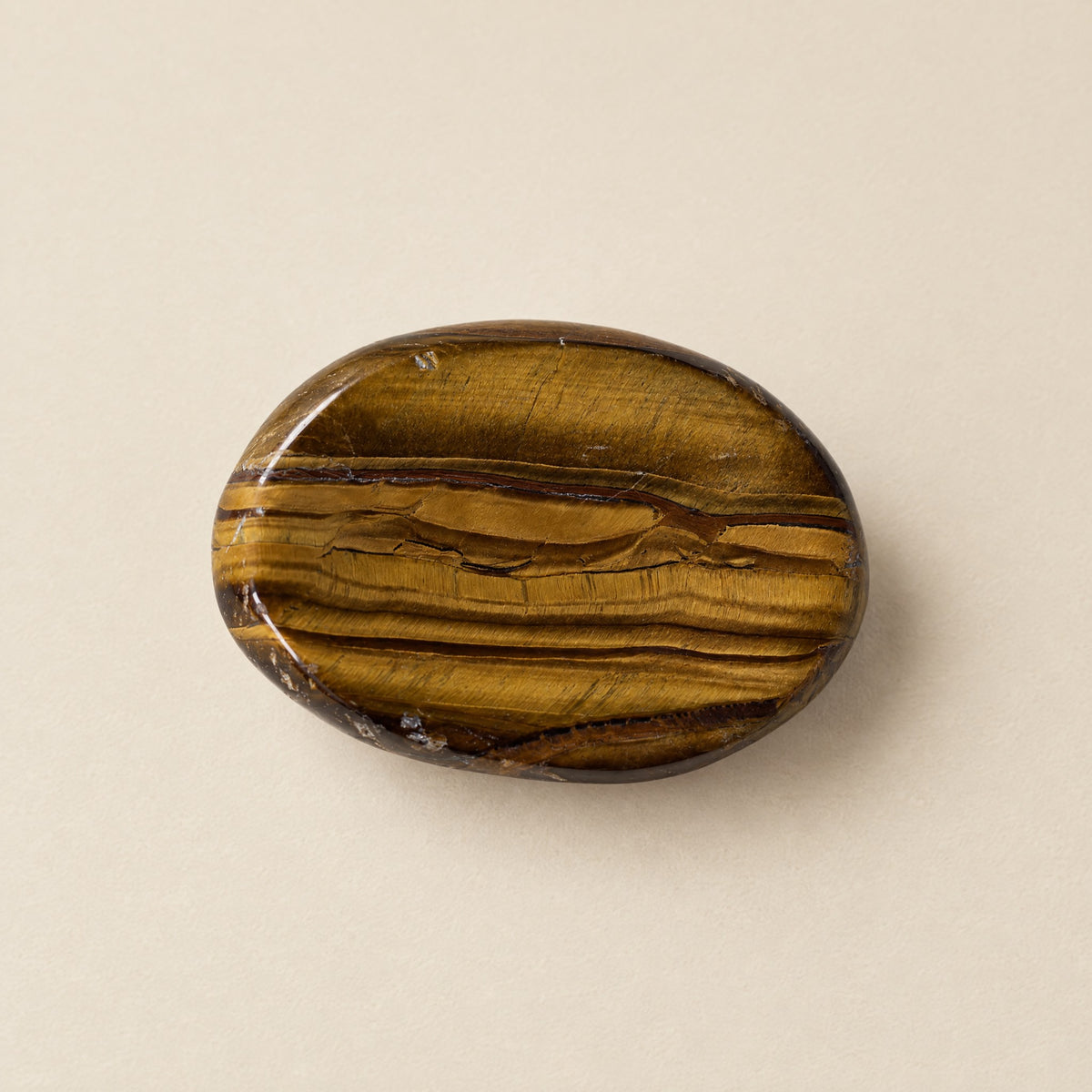 Polished tiger eye worry stone with thumb dip