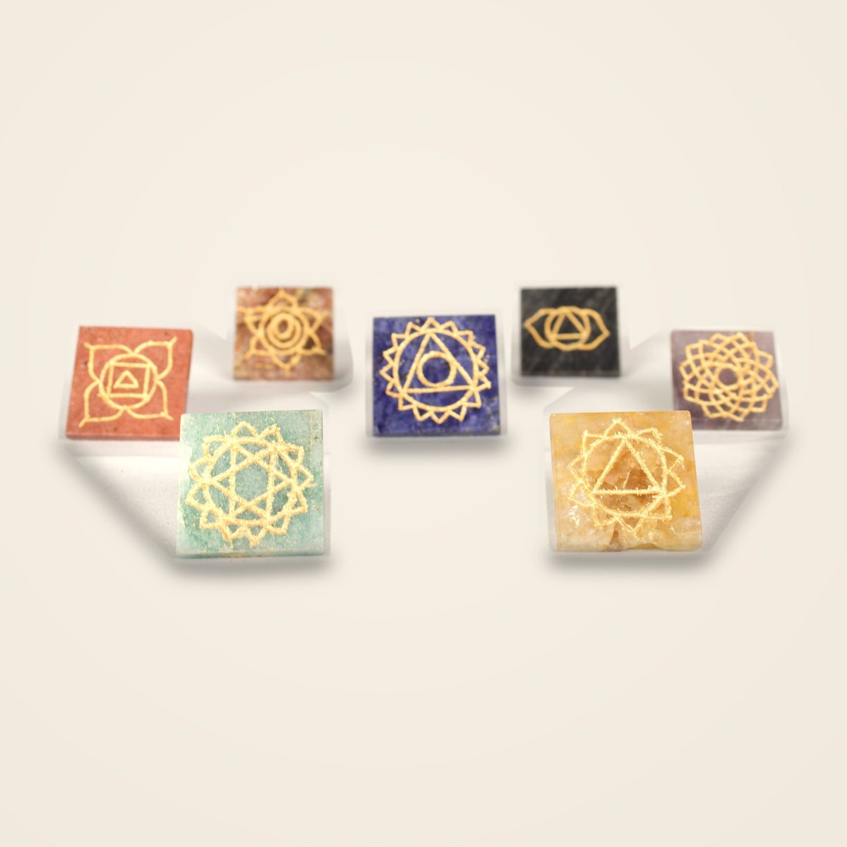 The same 7 pyramids turned over to show the gold-tone chakra symbol on each base