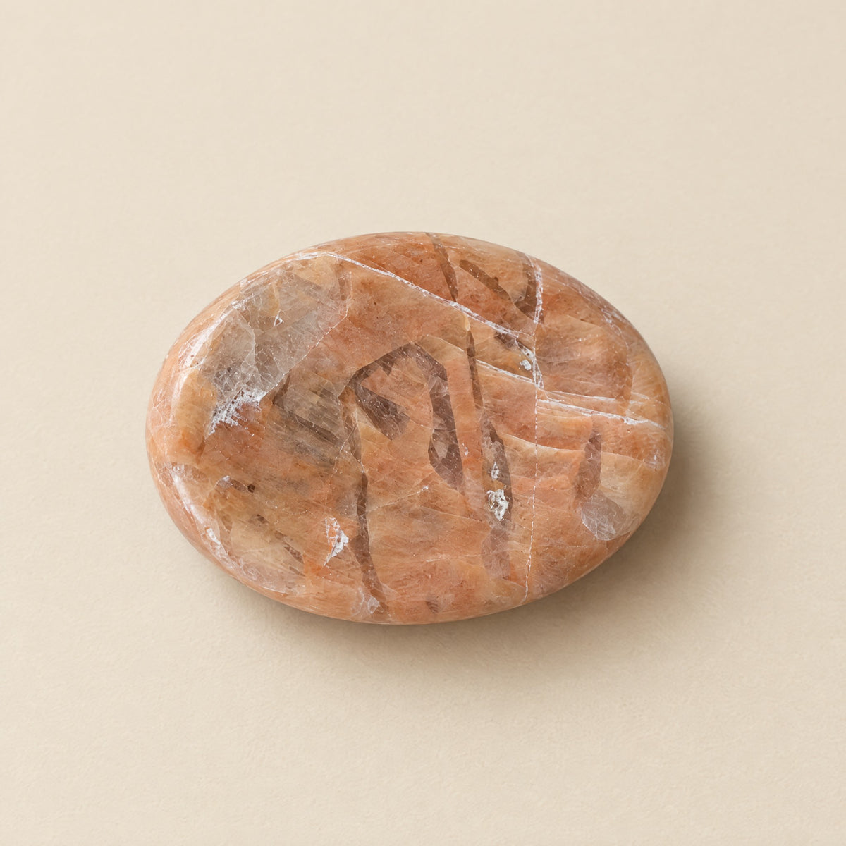 Polished peach moonstone worry stone with thumb dip